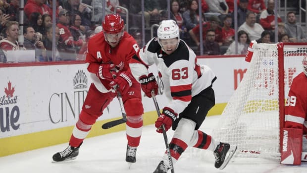 Oct 25, 2022; Detroit, Michigan, USA; Jesper Bratt #63 of the New Jersey Devils fights for control of the puck with Ben Chiarot #8 of the Detroit Red Wings during the third period of the game at Little Caesars Arena. Mandatory Credit: Brian Sevald-USA TODAY Sports
